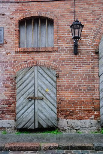 A vertical shot of a window and a door on a building in Riga