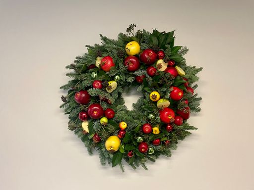 Top view of a beautiful decorative festive wreath with red and yellow apples isolated on white background.