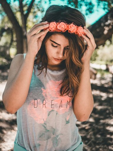 A beautiful Mexican young woman with a Crown of roses looking down in a park in Chihuahua, Mexico
