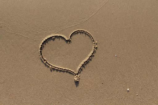 A closeup shot of heart drawing on the sand