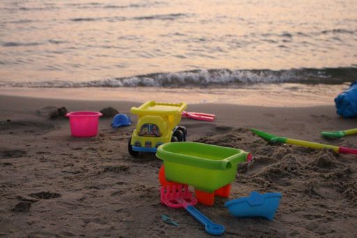 A closeup shot of plastic toys on the sand of the beach