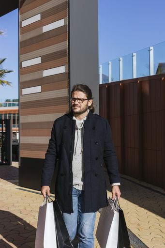 A man walking down the street with purchases