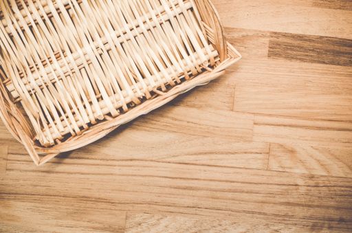 A high angle shot of a woven basket on a wooden surface