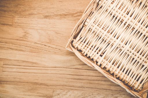 A high angle shot of a woven basket on a wooden surface
