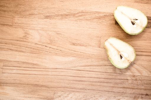 A high angle shot of half-cut pears on a wooden surface