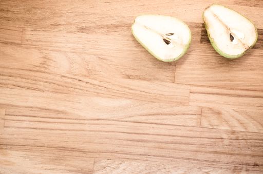 A high angle shot of half-cut pears on a wooden surface