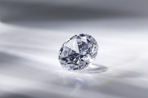 A closeup shot of a beautifully cut diamond on a white surface