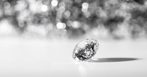 A closeup shot of a beautifully cut diamond on a white surface