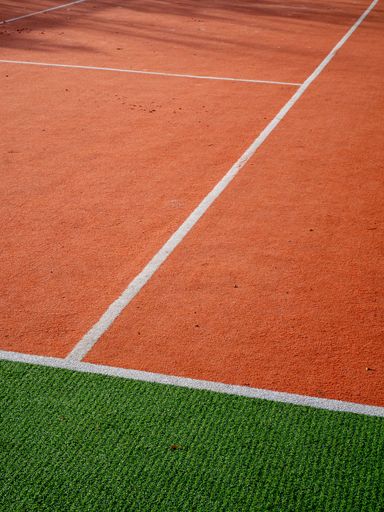 A vertical shot of bright orange and green running track in the stadium