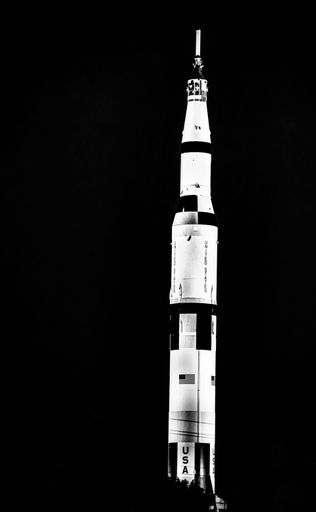 A grayscale of Saturn V NASA rocket against a sunset sky at the space and rocket center