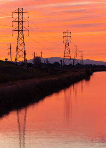 A beautiful view of magnificent power lines in the background of a wonderful sunset