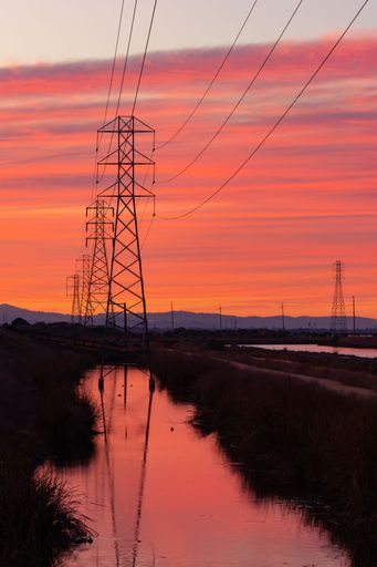 A beautiful view of magnificent power lines in the background of a wonderful sunset