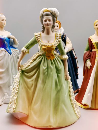 A vertical shot of a vintage renaissance figurine on gray background