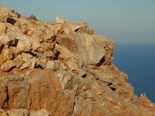 A closeup shot of a rocky cliff edge near the sea in Crete, Greece