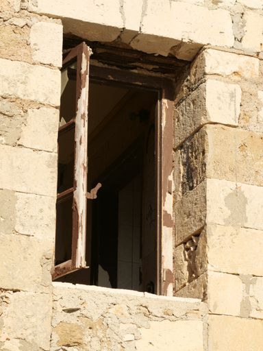 A vertical shot of an old window on a brick wall