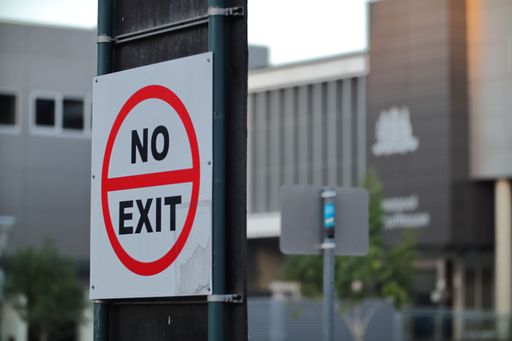 A no-exit sign taped to a metal pole
