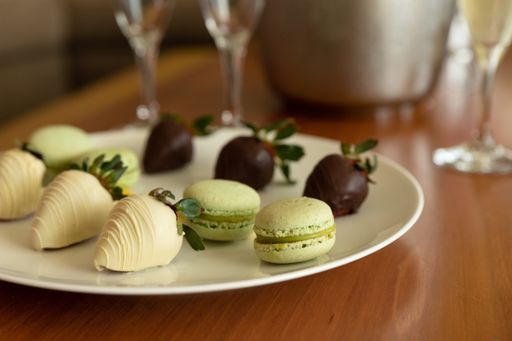 A selective focus shot of delicious macaroons and chocolate-covered strawberries