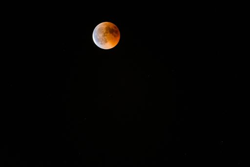 The half-red full moon against a dark background at night - great for wallpapers