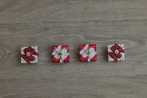 A top view of hanging small Christmas gift boxes on a wooden table with copy space