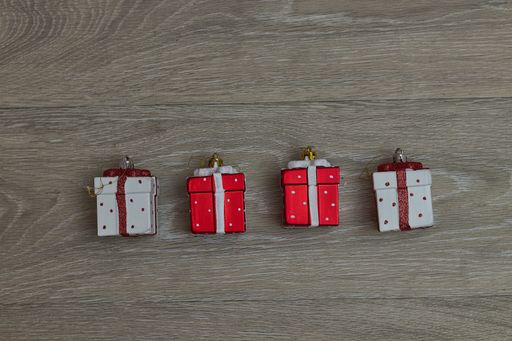 A top view of hanging small Christmas gift boxes on a wooden table with copy space