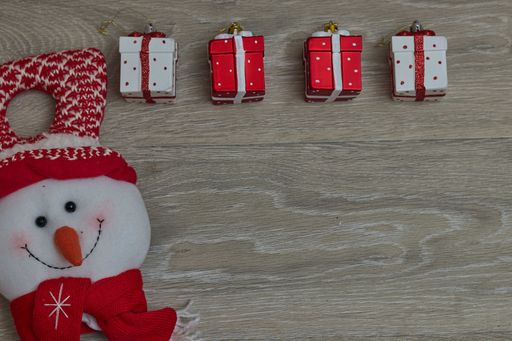 A top view of hanging small Christmas gift boxes on a wooden table with copy space