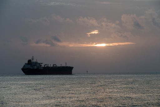 A huge ship in a sea under a cloudy sky during a beautiful sunset in the evening