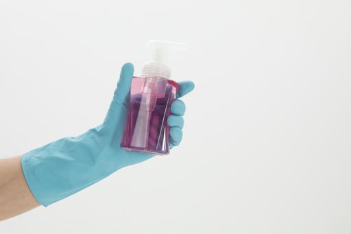 An isolated shot of a hand holding an alcohol spray on a white background - concept COVID19 prevention