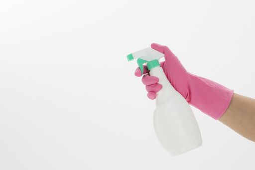 An isolated shot of a hand holding an alcohol spray on a white background - concept COVID19 prevention