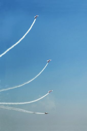 A vertical low angle shot of acrobatic airplanes evolutions during airshow Turin, Italy