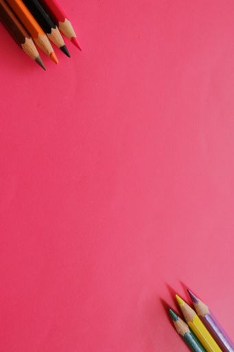 Colorful pencils laying on a red background