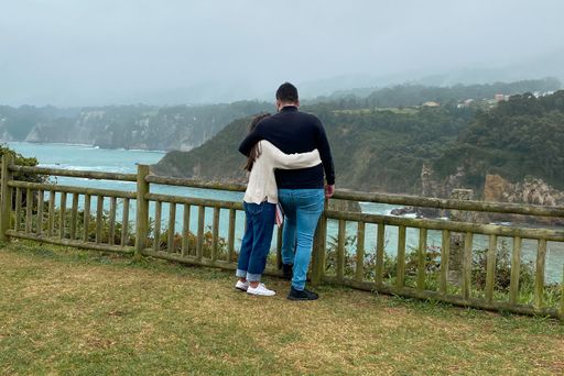 A beautiful shot of a male and female couple hugging in the Ermita de la Regalina in Asturias, Spain