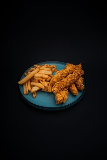A closeup shot of a tasty looking dish with fried chicken and fries isolated on a black background