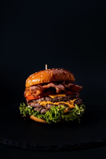 A closeup shot of a tasty looking burger isolated on a black background