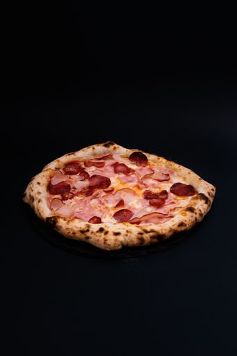 A vertical shot of a delicious pizza on a black surface