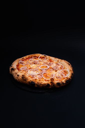 A vertical shot of a delicious pizza on a black surface
