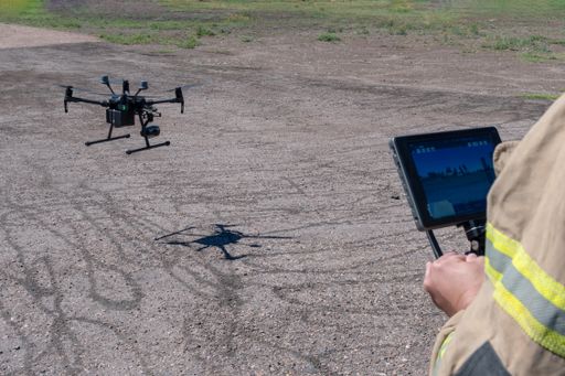 A firefighter navigating a flying drone with remote control
