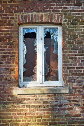 A vertical shot of a window with broken glass