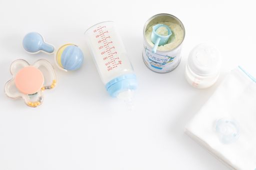 A top view shot of feeding bottles, baby food, baby rattle, pacifier and disposable towels