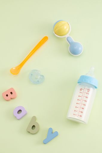 A vertical shot of baby care items on pastel green background