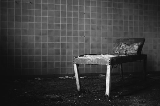 A closeup of an old decaying rusty medical bed in an abandoned room