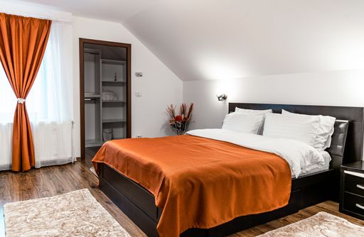 A nicely furnished bedroom with a comfortable bed inside of a modern house, apartment