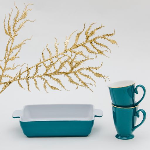 A vertical shot of a bowl and cup set and Christmas decorations on a white background