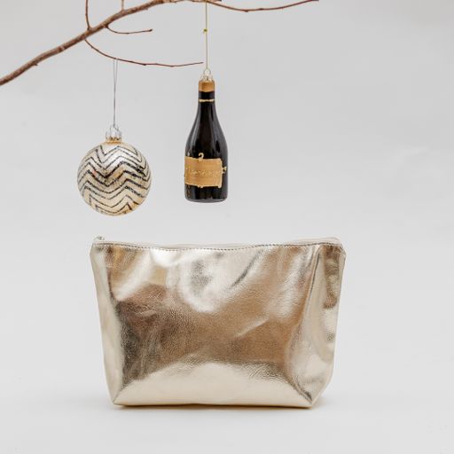 A vertical shot of a cosmetic bag and Christmas decorations on a white background
