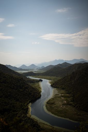 An aerial view of Rijeka Crnojevica river surrounded by lush green vegetation of Montenegro