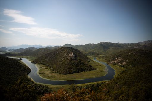 An aerial view of Rijeka Crnojevica river surrounded by lush green vegetation of Montenegro