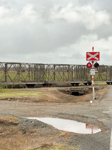 A freight train transporting canes is seen in the countryside of Australia