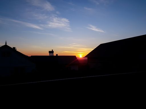 The silhouettes of roofs under a blue sky during a beautiful sunset in the evening