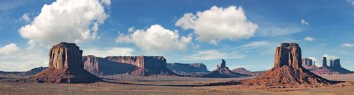 Breathtaking panoramic view of Monument Valley, Arizona, with its majestic red rock formations, iconic mesas, and dramatic desert landscape