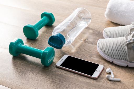 A high angle shot of sports equipment and a smartphone on a wooden surface