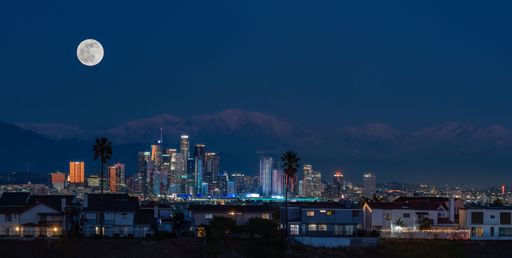A stunning nighttime shot of the downtown area of Los Angeles, California, USA, illuminated by the bright full moon